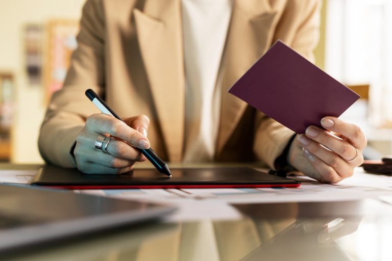 Persona firmando documentación de un trámite administrativo en una mesa de despacho
