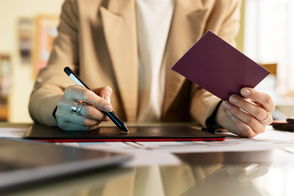 Persona firmando documentación de un trámite administrativo en una mesa de despacho
