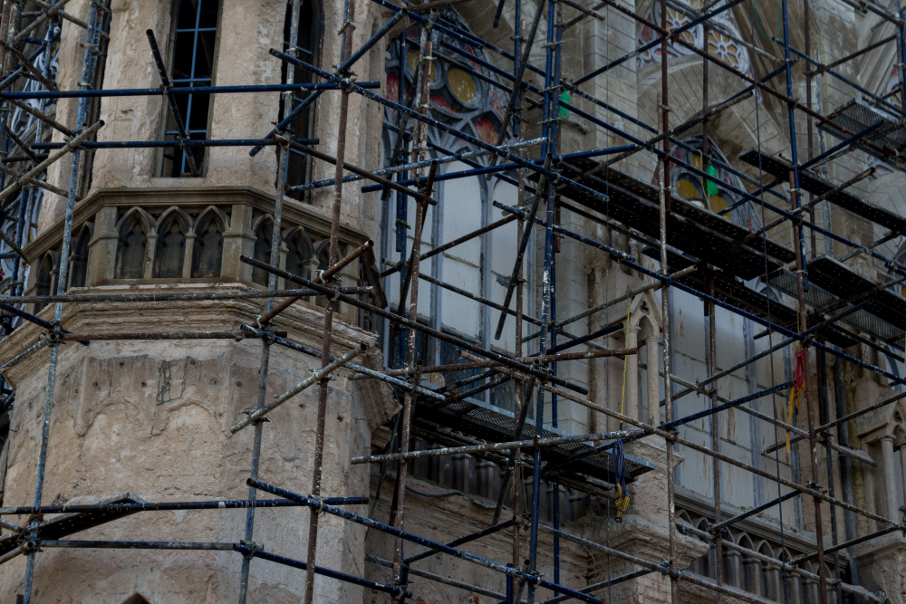 Técnico revisando una pared de ladrillo con patologías en un edificio antiguo